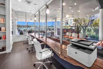 A modern office with a large printer on the desk.